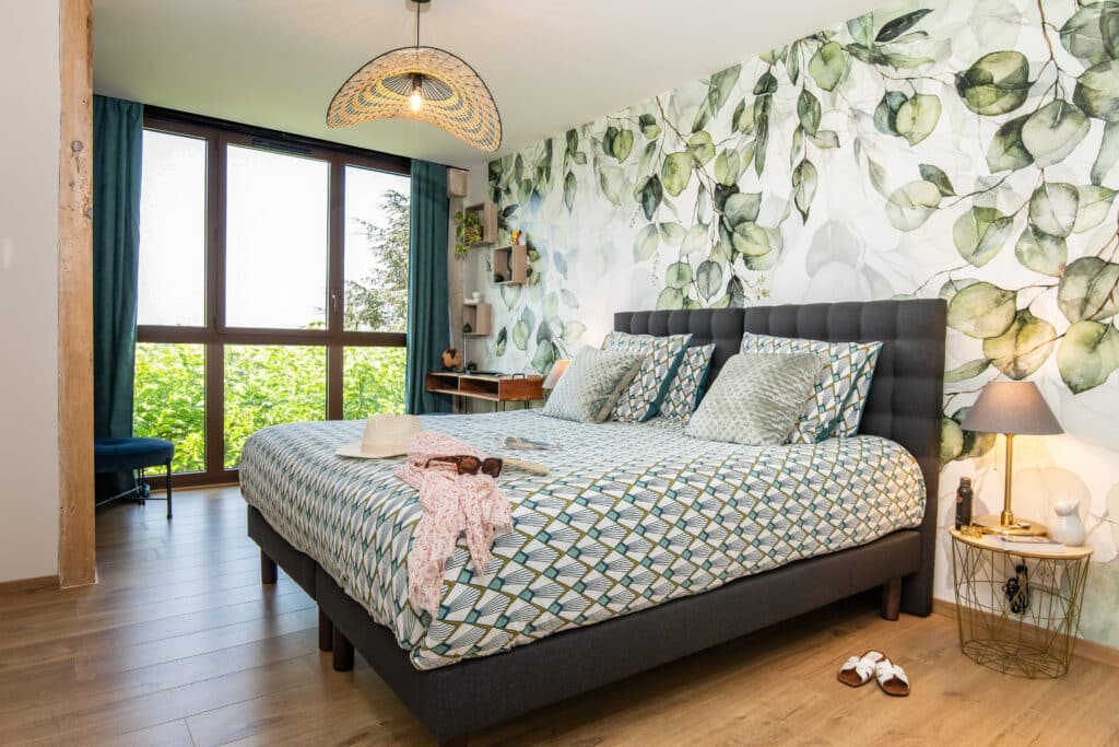 Chambre moderne avec décor végétal, lit double.