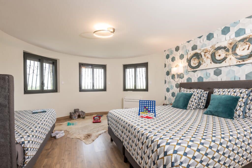 Chambre moderne avec lit double et décor géométrique.