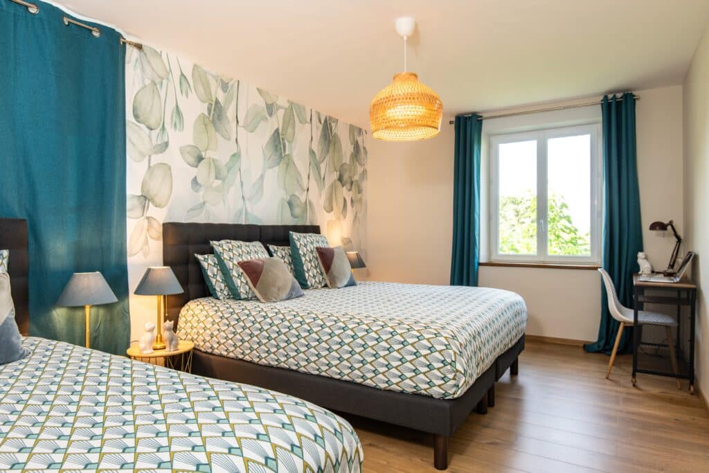 Chambre moderne avec lits et déco végétale.
