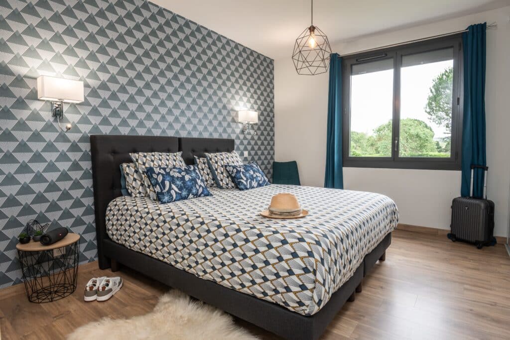 Chambre moderne avec lit double et décoration géométrique.