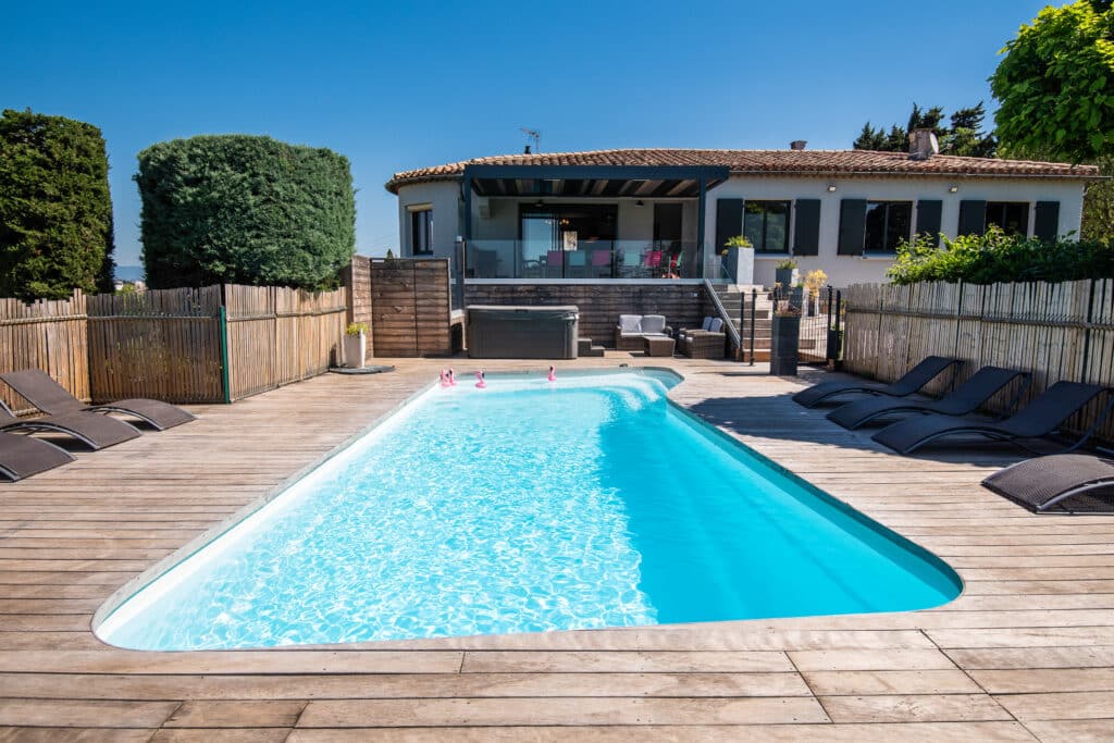 Piscine extérieure avec terrasse en bois.