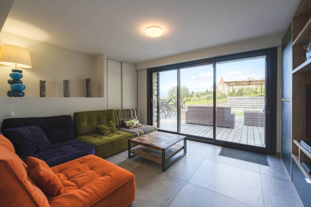 Salon moderne avec terrasse et vue sur jardin.