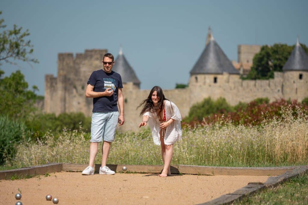Jouer à la pétanque devant un château historique.