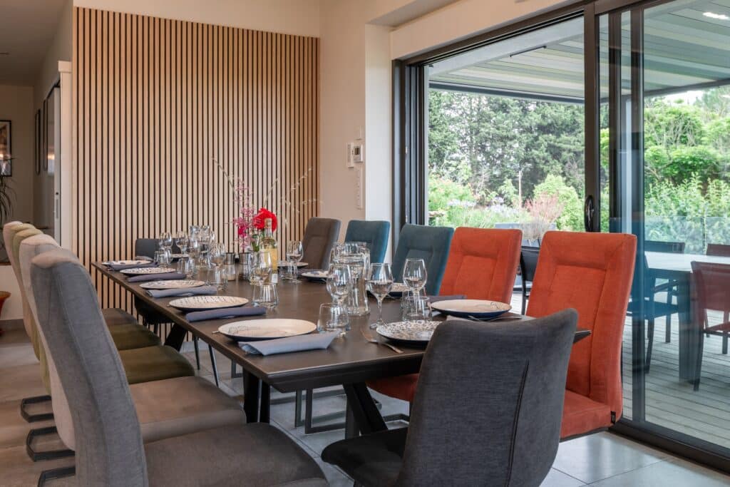 Salle à manger moderne avec grande table dressée.