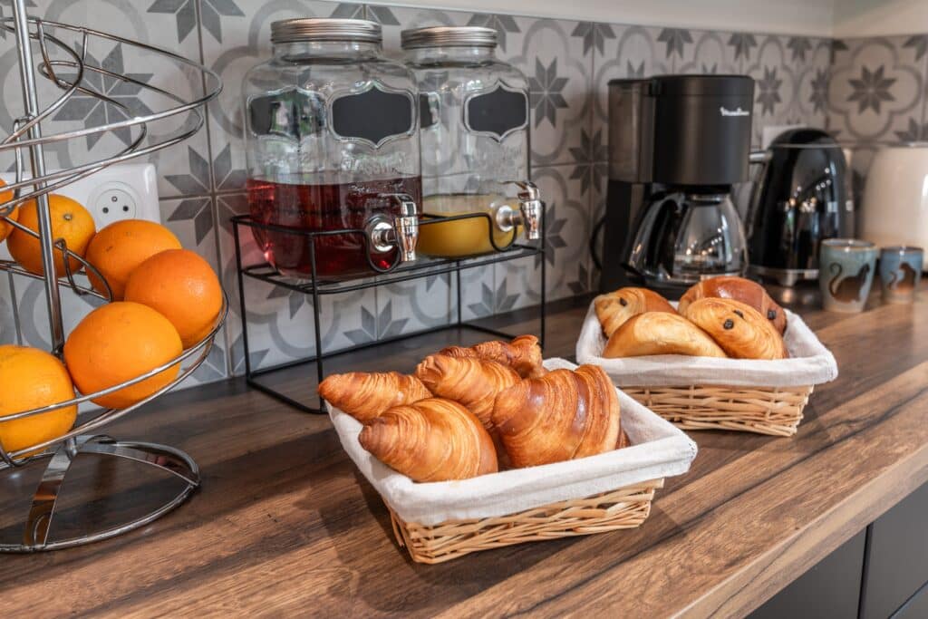 Petit déjeuner avec croissants et jus sur table.