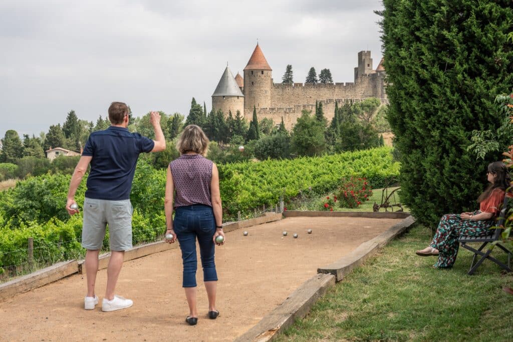 Jouer à la pétanque devant le château médiéval.