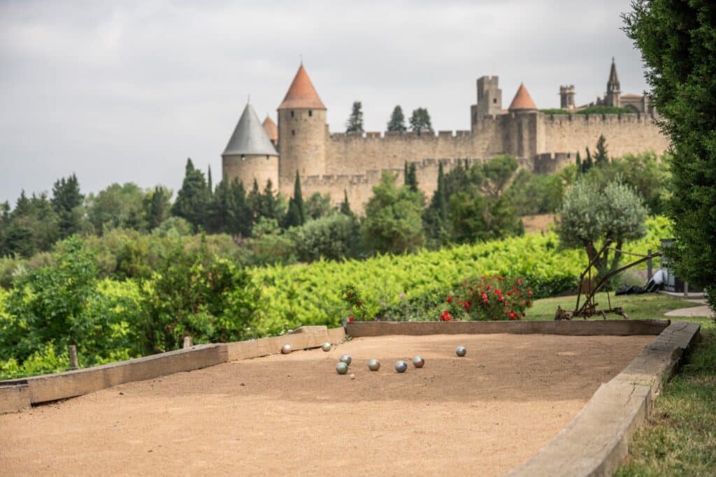 Jeu de boules devant un château médiéval français.