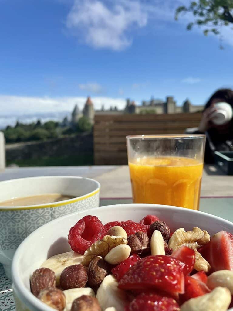 Petit-déjeuner coloré en terrasse, vue sur le château.