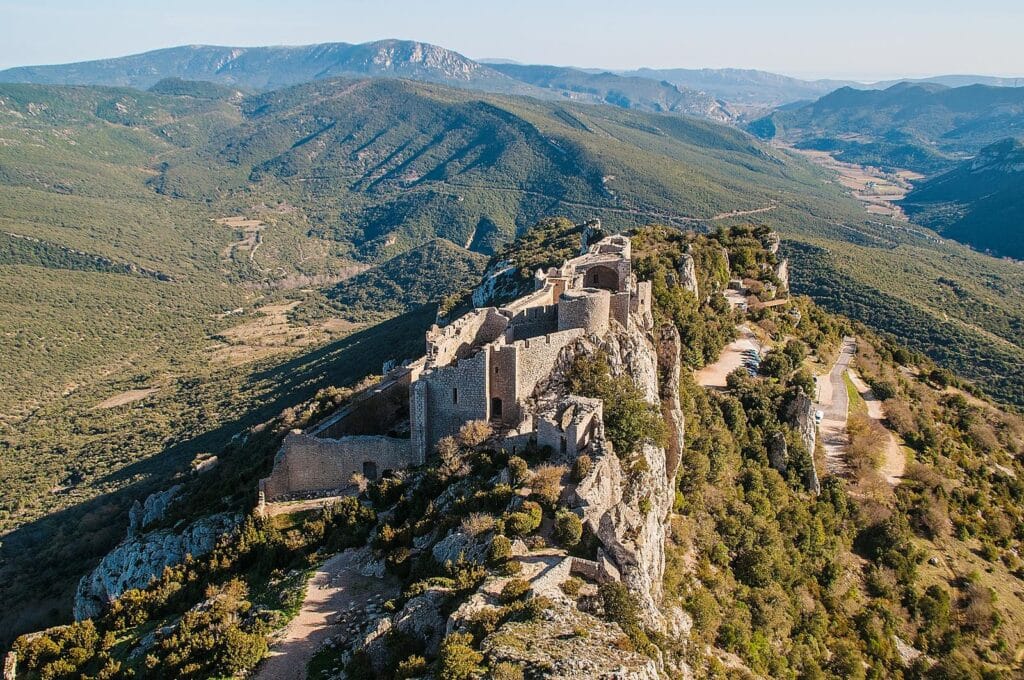 Château médiéval sur colline verdoyante, paysages magnifiques.
