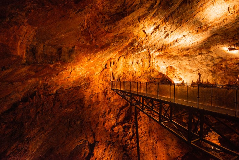 Passerelle illuminée dans une grotte en France.