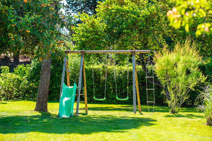 Aire de jeux extérieure avec balançoire et toboggan.