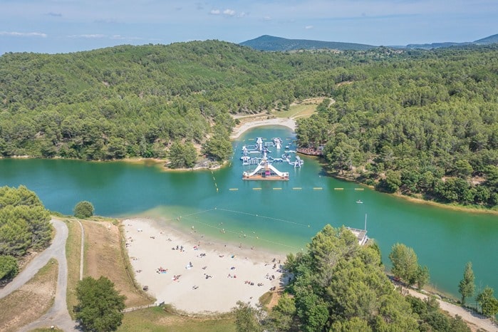 Lac avec plage et structures gonflables.