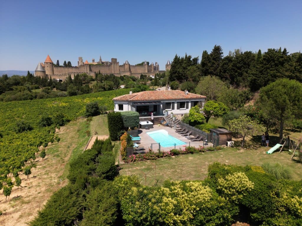 Maison avec piscine près d'un château médiéval en France.