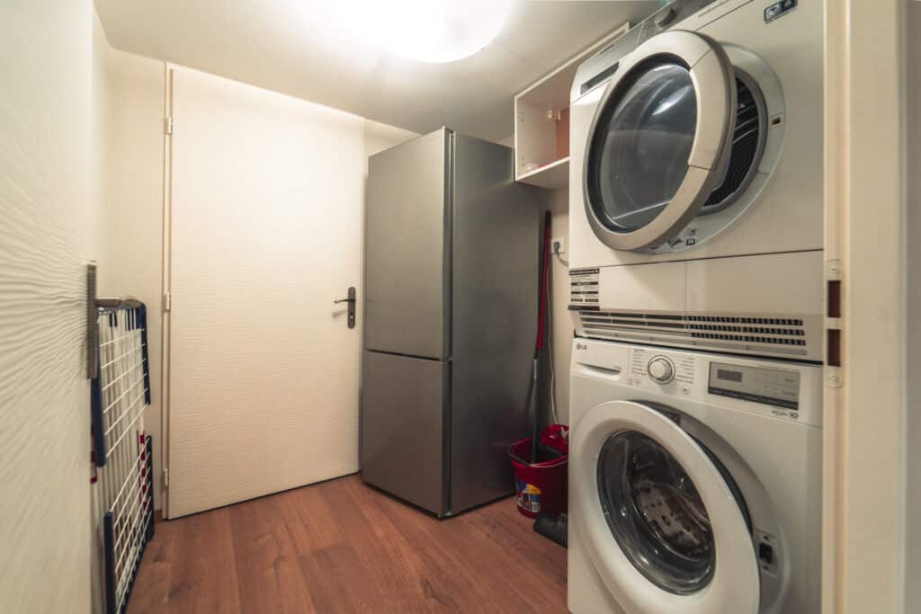 Buanderie avec lave-linge et sèche-linge superposés.