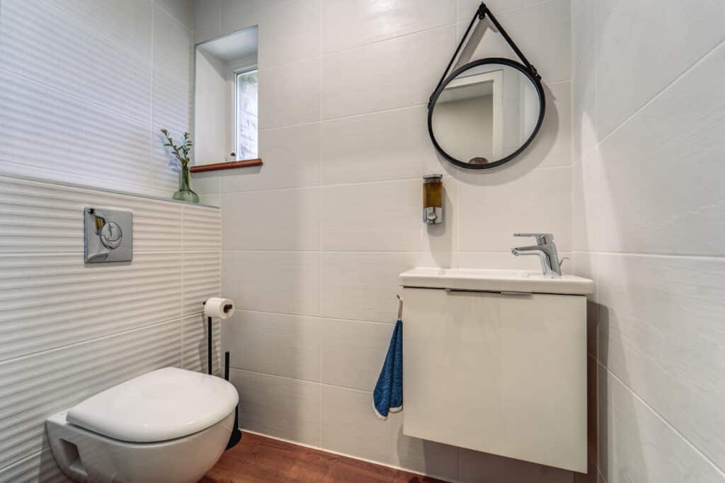 Salle de bain moderne avec miroir et lavabo.