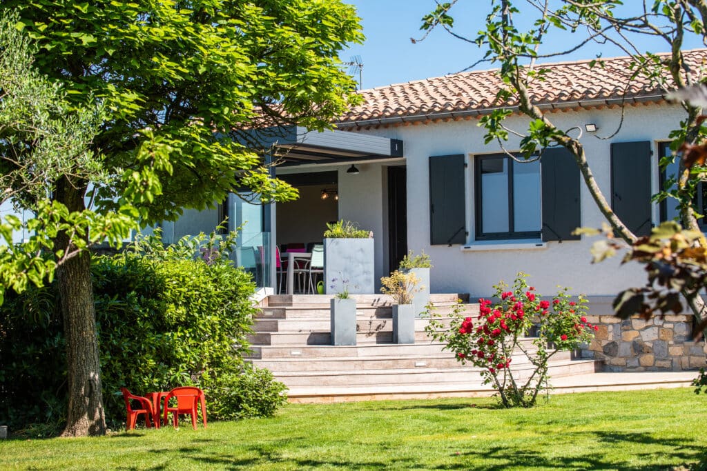 Maison avec jardin verdoyant en été.