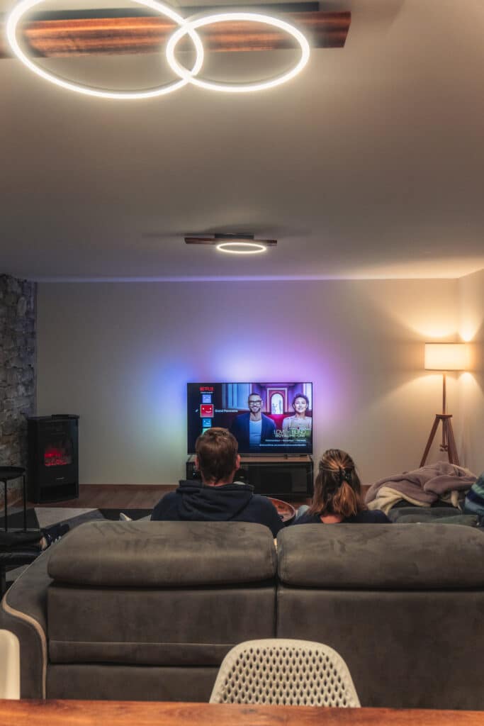 Couple regardant la télévision dans un salon moderne.