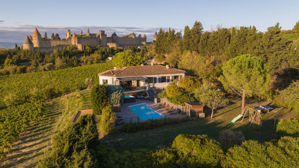 Vue aérienne maison avec piscine, vignoble et château