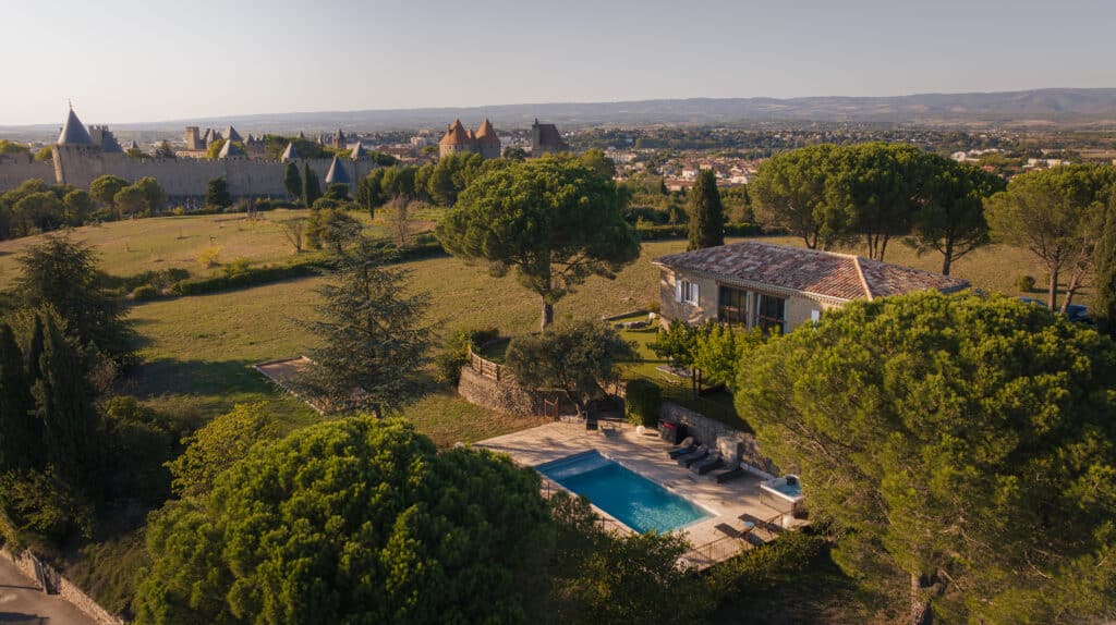 Vue aérienne de Carcassonne et maison avec piscine.