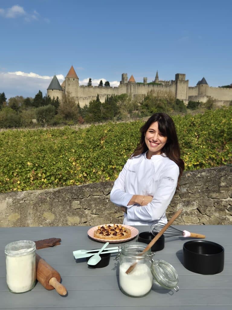 Chef devant château avec dessert et ustensiles.