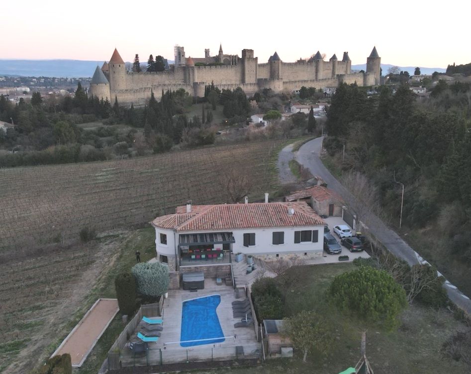 Vue aérienne de Carcassonne et maison avec piscine.