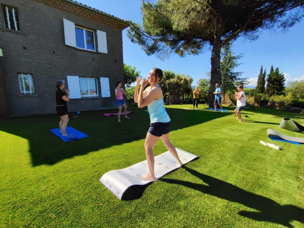 Cours de yoga en plein air devant maison.