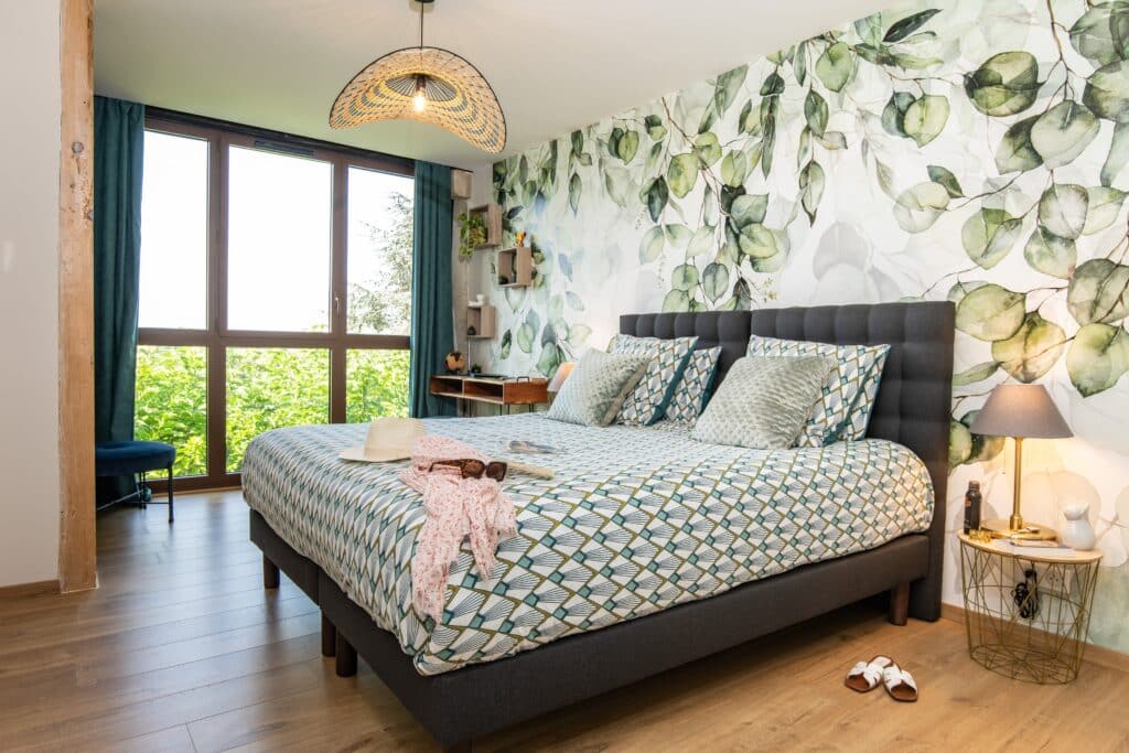 Chambre moderne avec lit double et décor végétal.