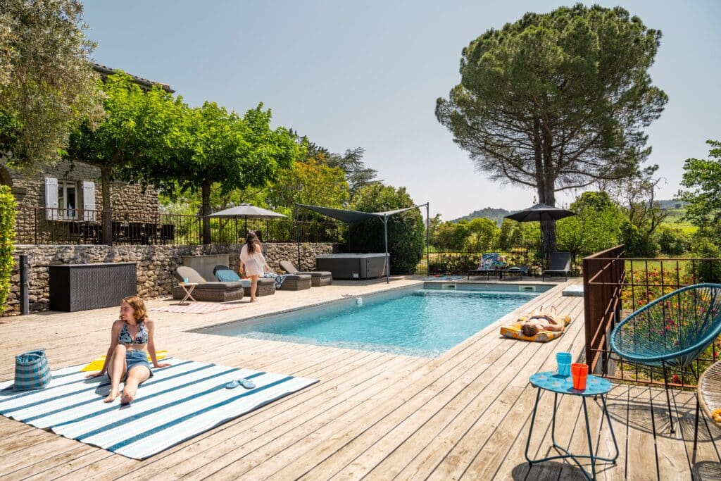 Piscine en plein air avec terrasse ensoleillée.