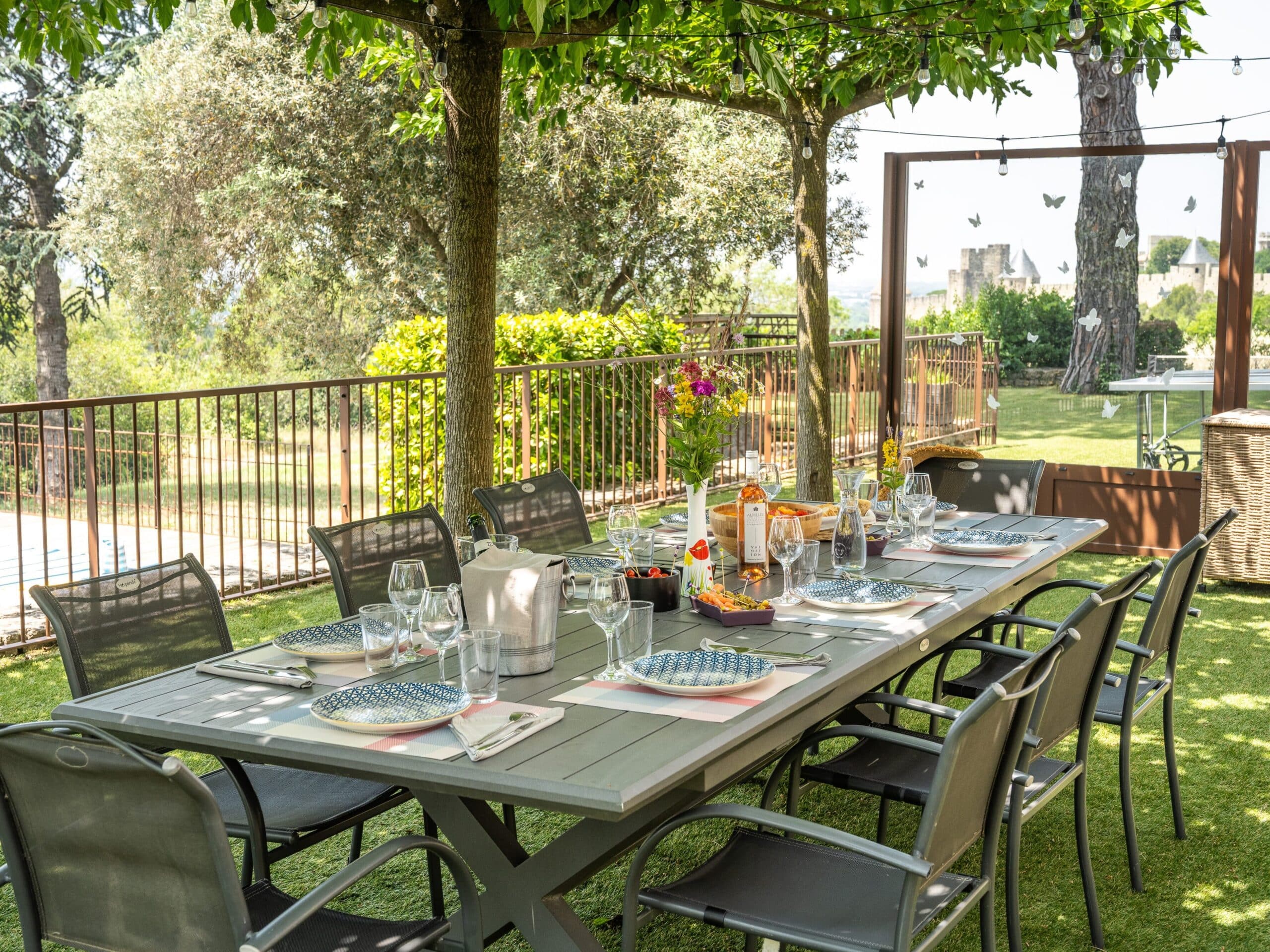 Table extérieure dressée vue piscine et Cité de Carcassonne- L'Écrin Grand Panorama