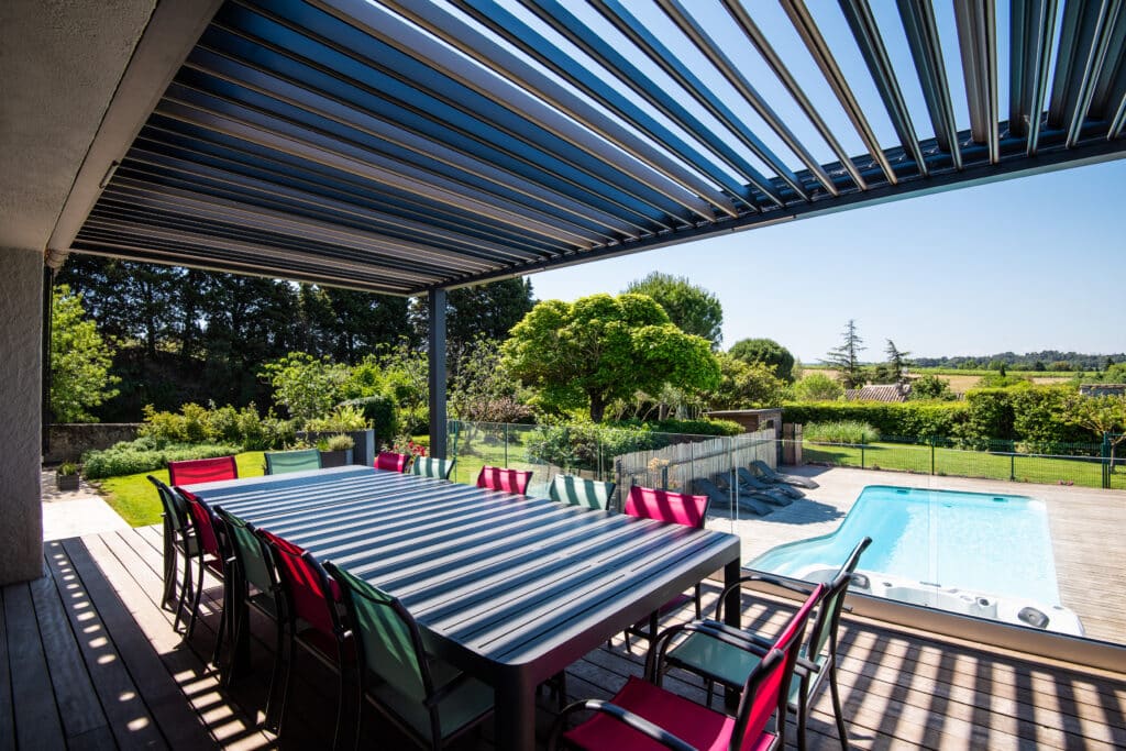 Terrasse moderne avec piscine et jardin ensoleillés.