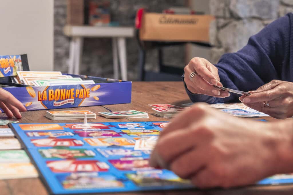 Joueurs autour d'un jeu de société sur la table.